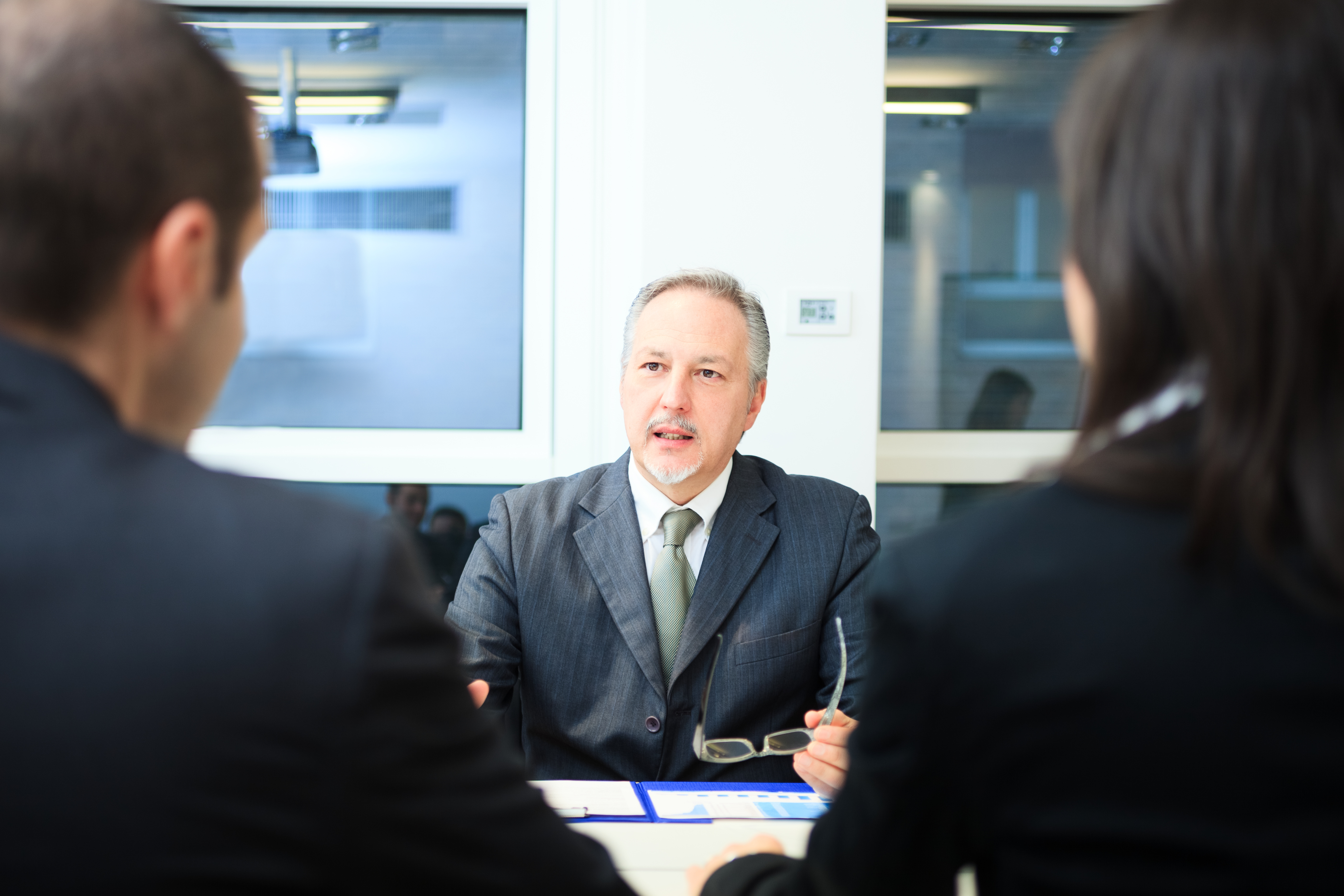 Businessman talking to a couple in a office