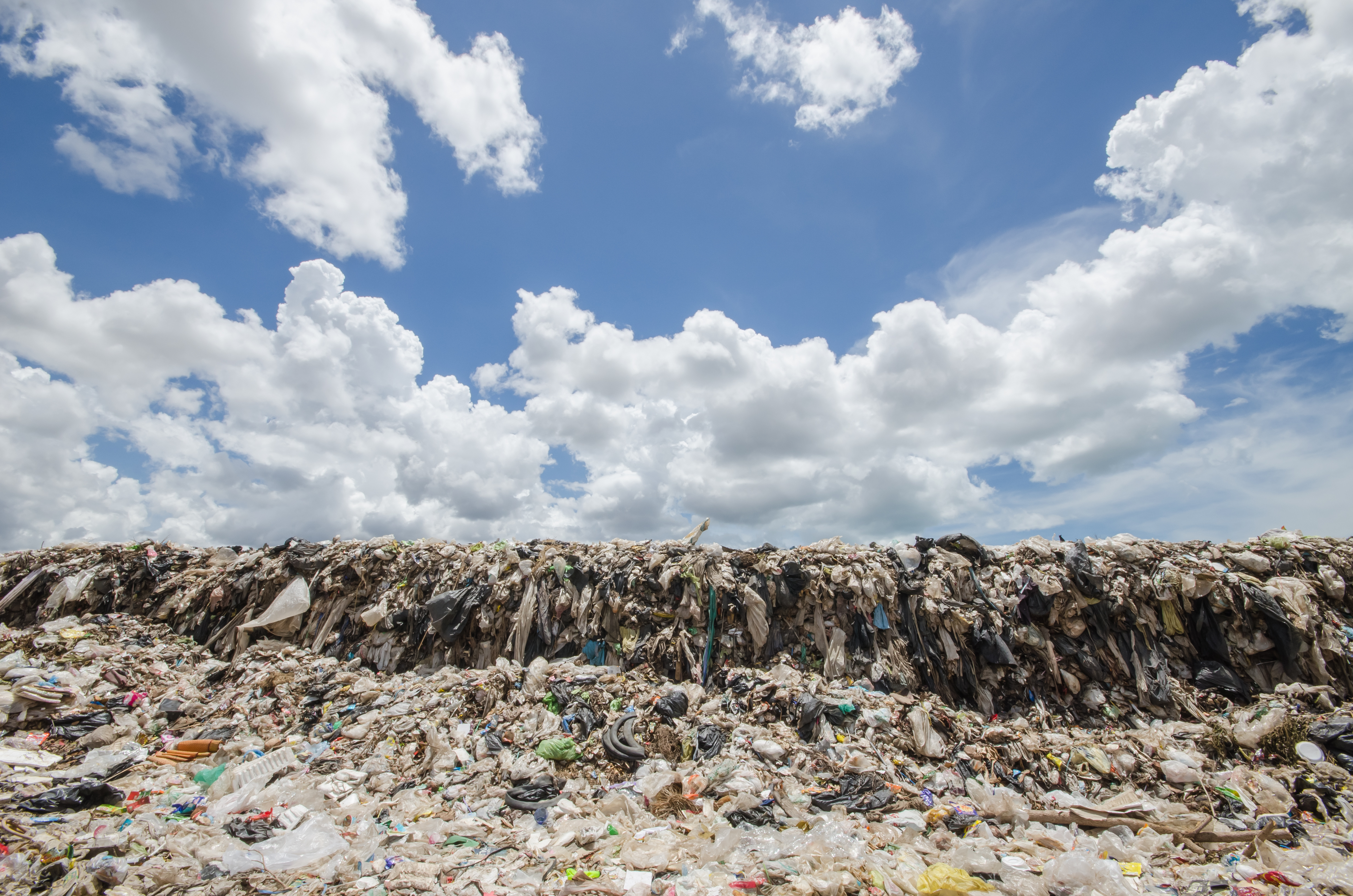 big garbage heap under blue sky