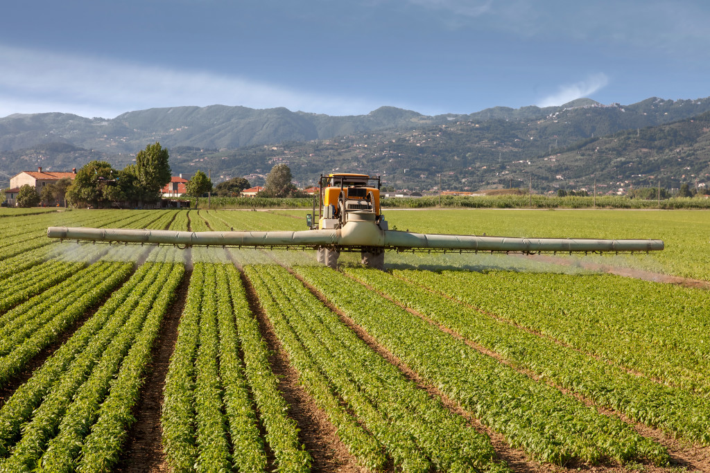 agriculture, tractor spraying pesticides on field farm