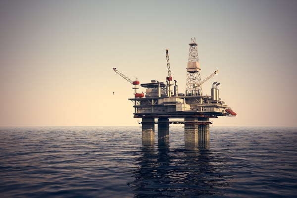 Image of oil platform while cloudless day. Oil platform on sea is offshore structure with facilities to drill wells, extract and process oil and natural gas and temporarily store produced goods until it can be brought to the shore for refining.