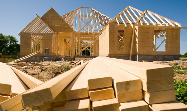 A new home being built with wood, trusses, supports and a foundation.