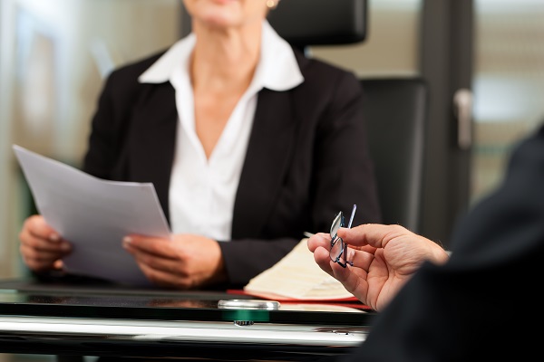 Mature female lawyer or notary with client in her office for counseling